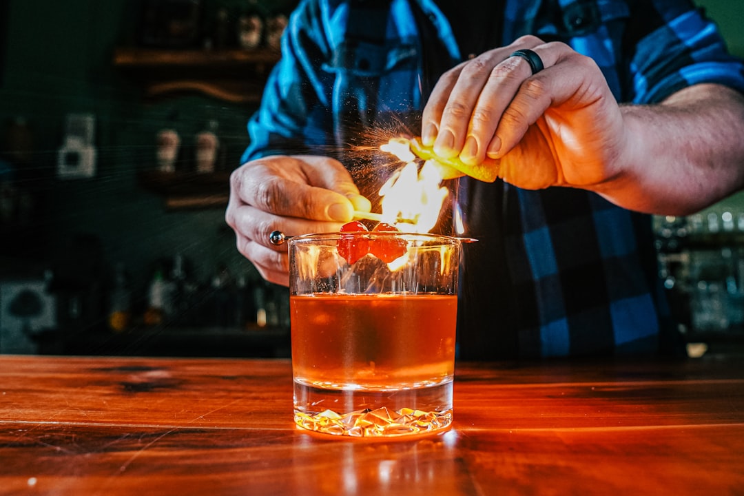 A man lighting a cigarette in a glass of alcohol