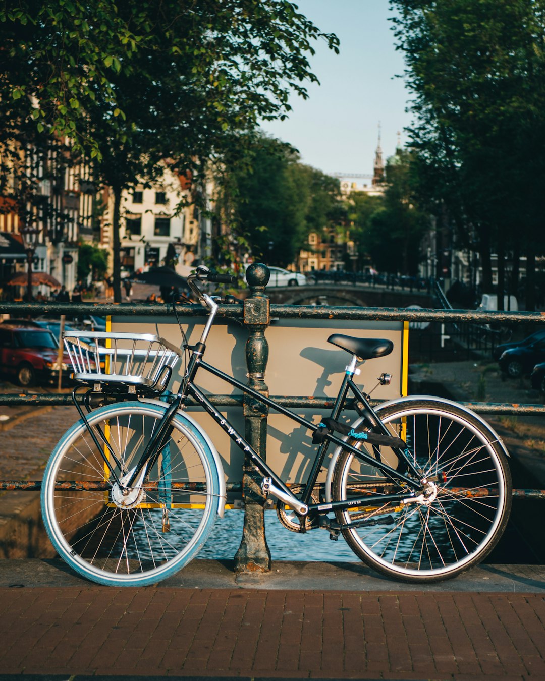 black city bike parked beside green tree during daytime